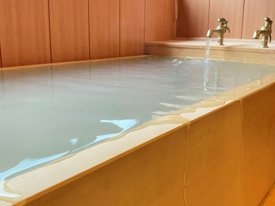 天然温泉の湯が溢れる檜の浴槽